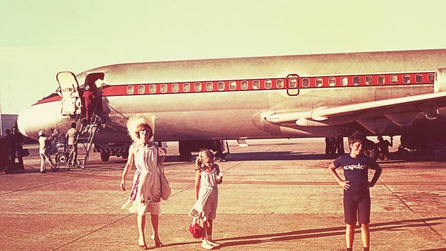 Vintage image of a mother and her children before boarding an airplane on a summer vacation.