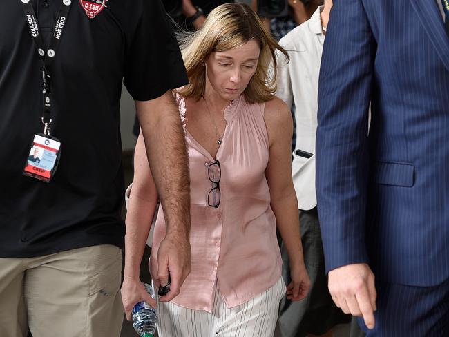 A distraught women is escorted by Coulson Aviation officials at Sydney International Airport today following the death of three American firefighters. Picture: AAP