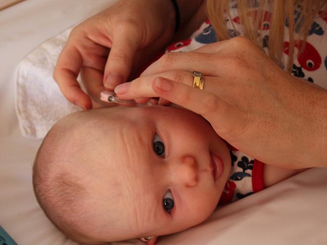 Clare Collins puts Milly's hearing aids in for the first time when she was just nine weeks old.