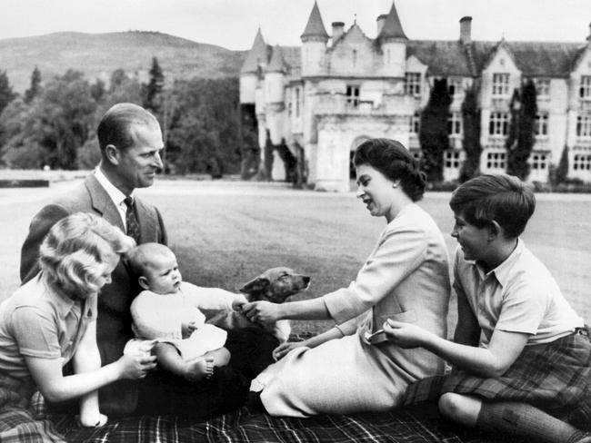 Queen Elizabeth II, Prince Philip sit at Balmoral with their children Princess Anne (L), Prince Charles (R) and the new-born Prince Andrew (C) playing with a corgi on September 8, 1960 . Picture: AFP