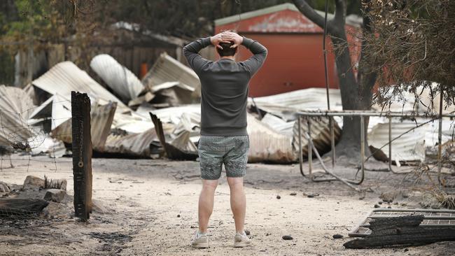 A local stops to observe the damage on Bastion Point Road. Picture: David Caird