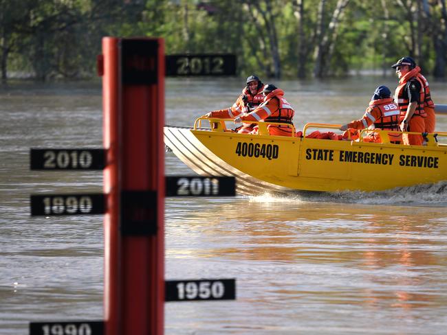 A State Emergency Service (SES) crew motors past a flood gauge on the swollen Balonne river in St George, south-western Queensland, Wednesday, February 26, 2020. The Balonne river is expected to break its banks and peak over 12 metres on Thursday, causing floods. (AAP Image/Dan Peled) NO ARCHIVING