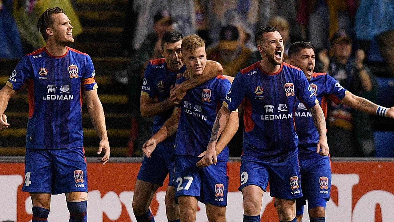 Riley McGee (centre) celebrates after his scorpion kick goal put the Jets ahead.