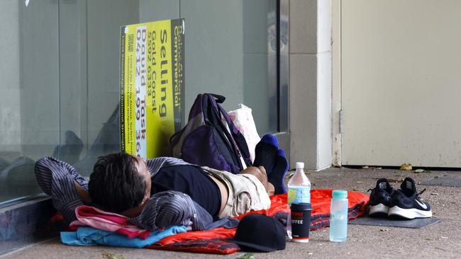 A homeless man takes advantage of an empty shopfront at Surfers Paradise. Picture: Tertius Pickard