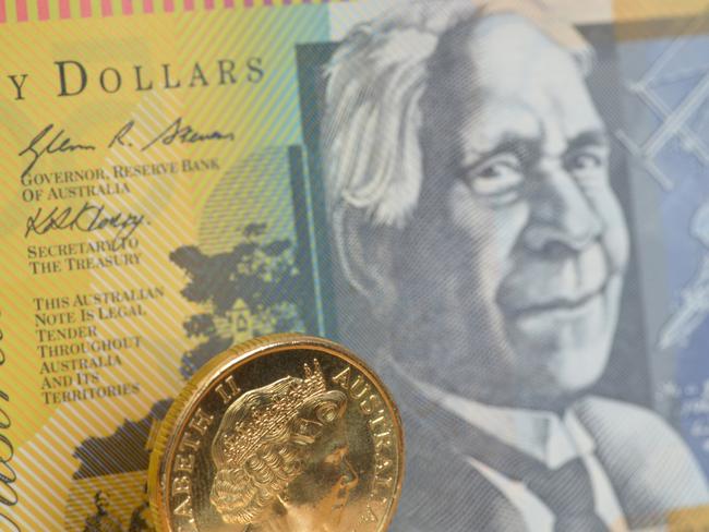 Focus on a one dollar coin with a fifty dollar note behind, Australian money generic notes, cash