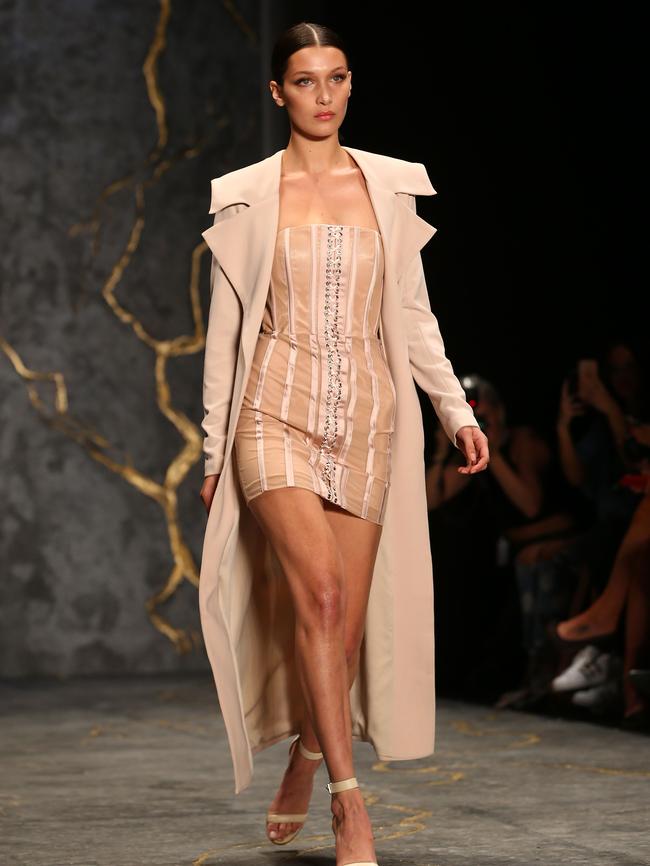 Hadid wears a blush-coloured short, strapless corset-styled mini dress and long, fluid coat. Picture: Getty Images