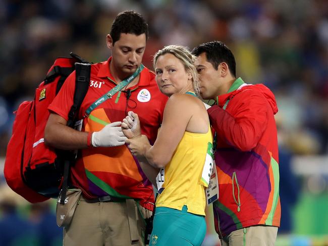 Kim Mickle of Australia is assisted by medical staff after being injured during the Women's Javelin Throw