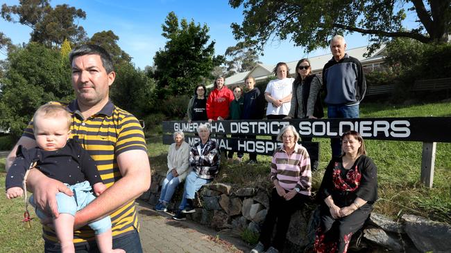 Gumeracha locals are calling on the State Government to reopen the local hospital's ED. Joel Taggart and one year old daughter Shiloh, with upset Gumeracha residents. Picture Dean Martin