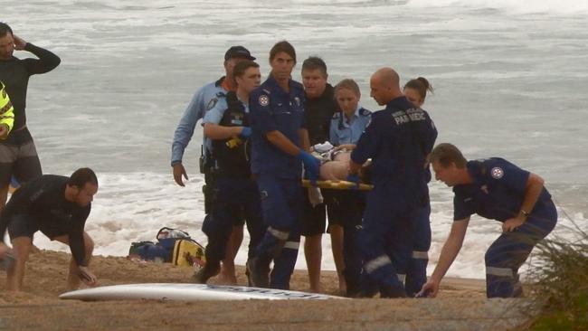 Paramedics stretcher the surfer up the beach after he was struck by lightning. Picture: TNV Video