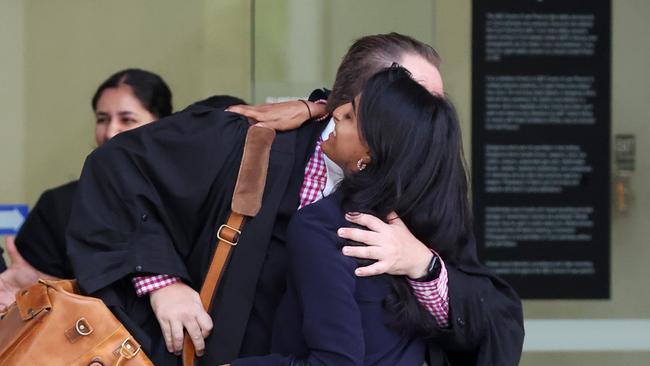 Maya Radhakrishnan hugs Crown Prosecutor Clayton Wallis while leaving the Supreme Court of Queensland, Brisbane. Picture: Liam Kidston