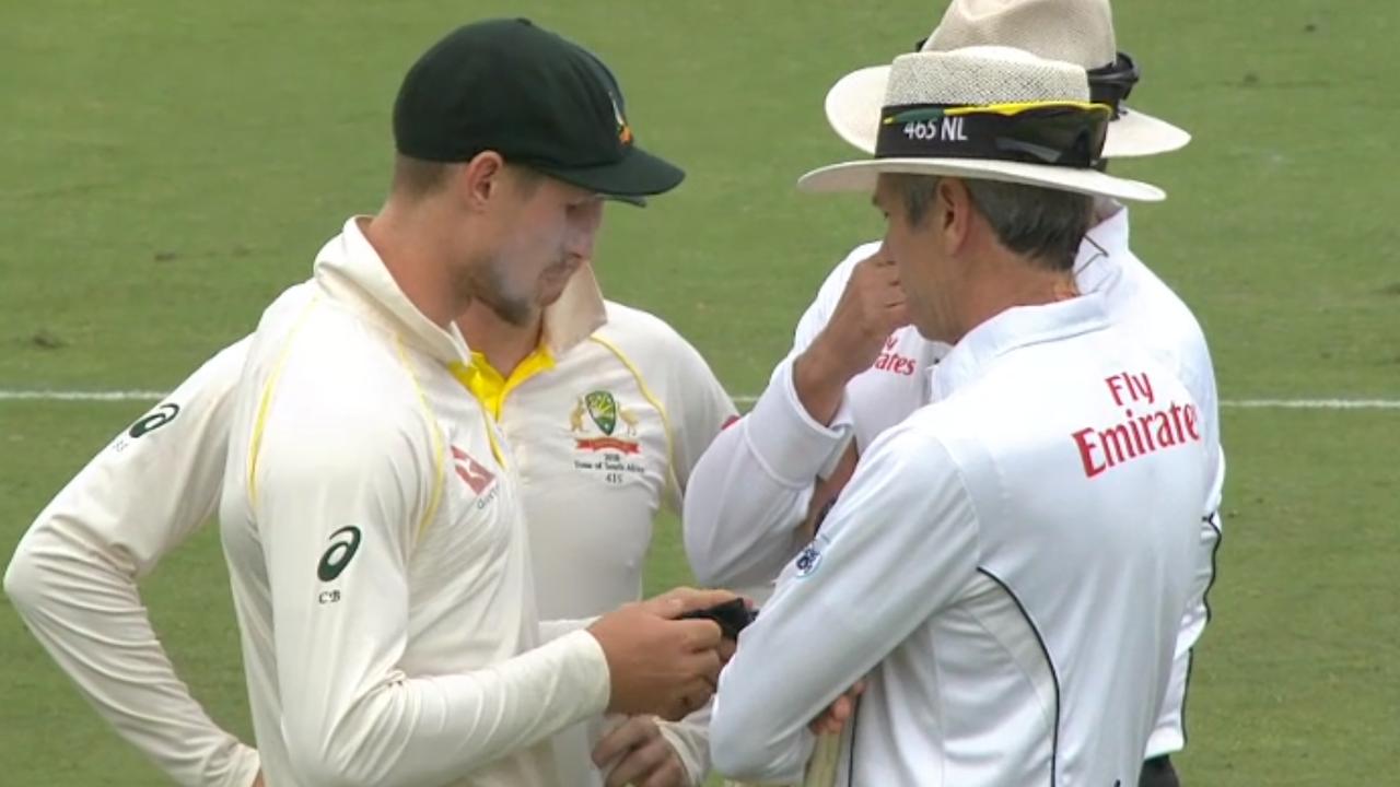 Bancroft shows the umpires his sunglasses cloth after he was accused of cheating.