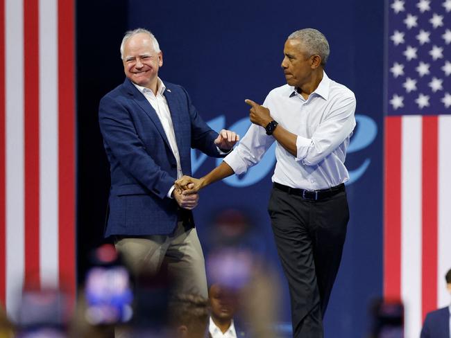 Former US President Barack Obama greets Minnesota Governor and Democratic vice presidential candidate Tim Walz during a campaign rally in support of Vice President and Democratic presidential candidate Kamala Harris, at Alliant Center in Madison, Wisconsin, on October 22, 2024. (Photo by KAMIL KRZACZYNSKI / AFP) / ALTERNATE CROP