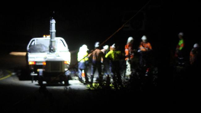 The workers appear to huddle together during their work.