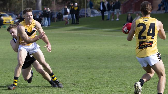 Brighton’s Chris Broadbent passes to teammate Nigel Osborn in their Adelaide Footy league division one fame against Adelaide University. Picture: Emma Brasier