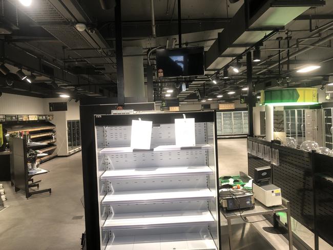 The interior of the former Woolworths 'Metro' supermarket on The Corso at Manly pictured on Monday. It still has shelving and fridges — and the lights turned on — despite closing its doors in February 2021. Picture: Jim O'Rourke