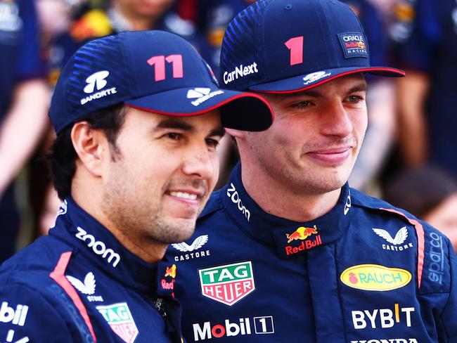 ABU DHABI, UNITED ARAB EMIRATES - NOVEMBER 26: Max Verstappen of the Netherlands and Oracle Red Bull Racing and Sergio Perez of Mexico and Oracle Red Bull Racing talk at the Red Bull Racing Team Photo prior to the F1 Grand Prix of Abu Dhabi at Yas Marina Circuit on November 26, 2023 in Abu Dhabi, United Arab Emirates. (Photo by Clive Rose/Getty Images)