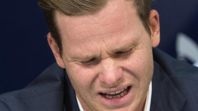 Suffering for his sins: Former Australian cricket captain Steve Smith, left, speaks to the media while his father, Peter, hold his hand on his back in Sydney. Picture: AP