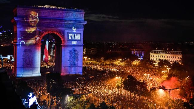 A portrait of French forward Kylian Mbappe projected on Paris' landmark Arc de Triomphe as people gather to celebrate France's victory in the Russia 2018 World Cup final. Picture: AFP