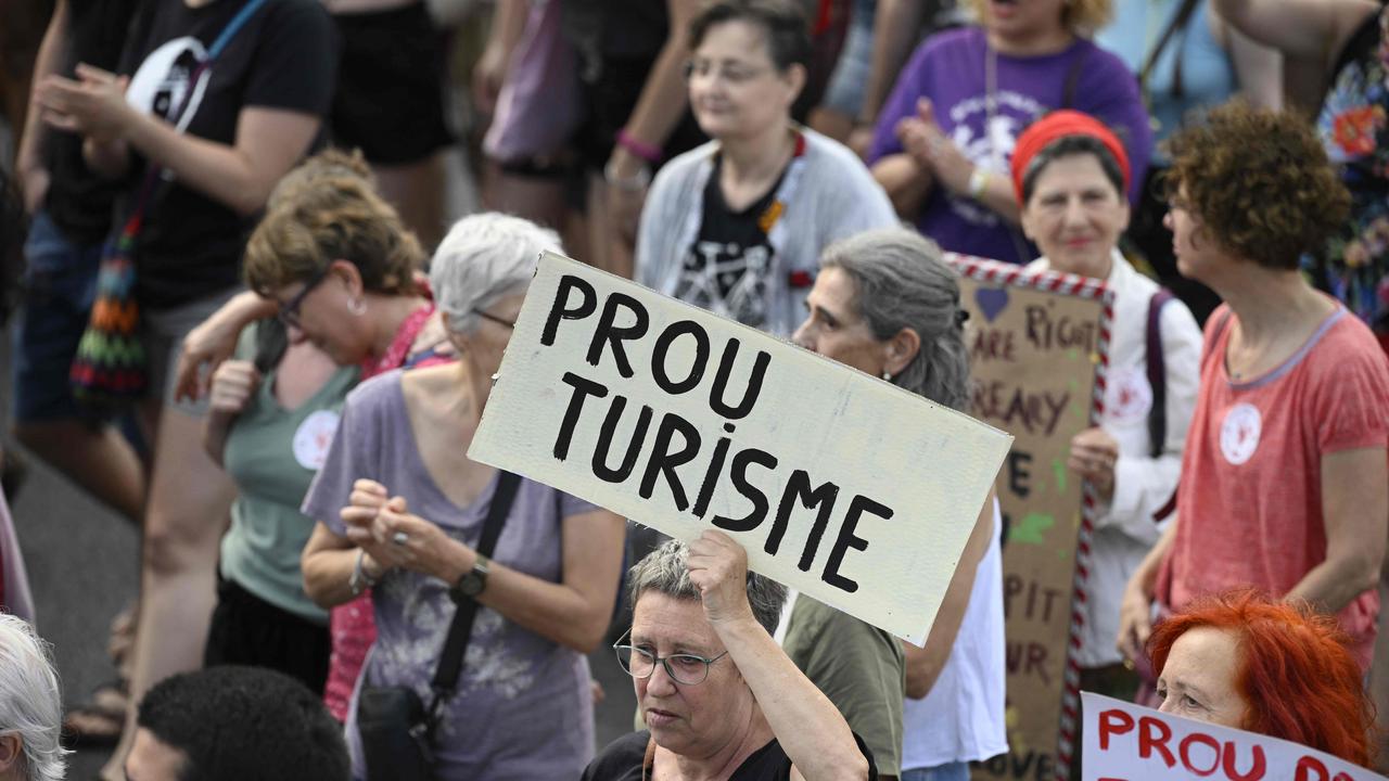 Demonstrators hold signs reading 'Enough tourism' during a protest against mass tourism on Barcelona's Las Ramblas alley, on July 6, 2024. Picture: Josep Lago / AFP