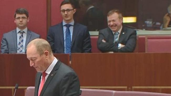 Speechwriter Richard Howard (far right) watches Senator Fraser Anning deliver his first speech to the Senate in Canberra on 14 August 2018.