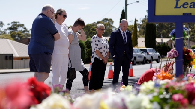 Premier Peter Gutwein spent some time outside Hillcrest Primary School where he laid a bunch of flowers at a growing tribute under the school's sign. Picture: NCA Newswire / Grant Viney