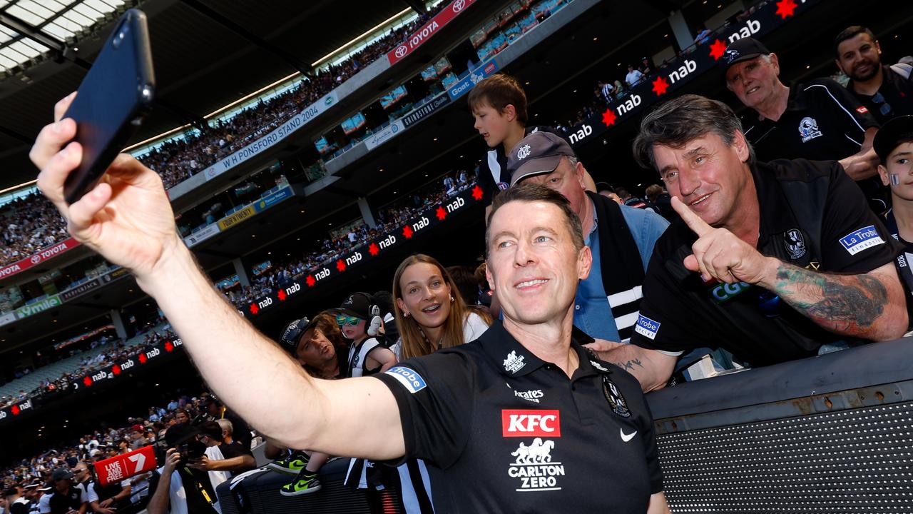 Craig McRae takes a photo with a fan before the bounce. Picture: Getty Images