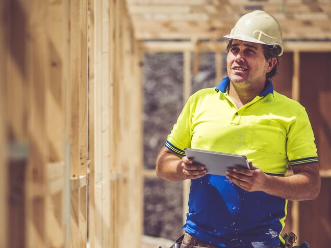 Construction worker on construction site, using digital tablet. He is checking if everything is ok.