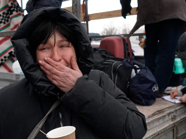 Evacuees from Mariupol are seen upon arrival at the car park of a shopping centre on the outskirts of the city of Zaporizhzhia, which is now a registration centre for displaced people, on March 16, 2022. - Some 20,000 residents have been allowed to leave Mariupol through a humanitarian corridor agreed with Russian forces. But exhausted, shivering evacuees speak of harrowing escape journeys and rotting corpses littering the streets. Mariupol is facing a humanitarian catastrophe according to aid agencies, since heavy bombardment has left some 400,000 inhabitants with no running water or heating and food running short. More than 2,100 residents have been killed in Mariupol since the Russian invasion, according to city authorities. (Photo by Emre CAYLAK / AFP)