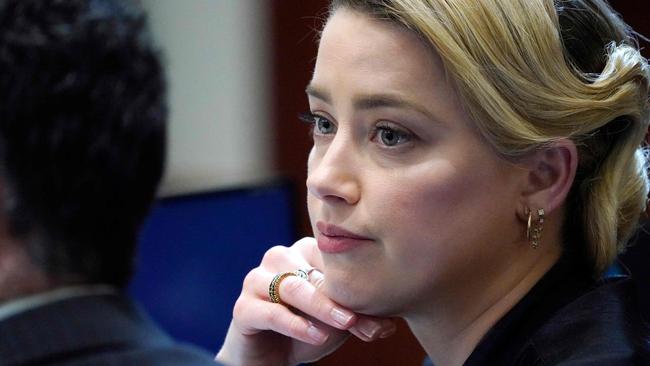 Actor Amber Heard talks to her lawyer in the courtroom at the court in Fairfax, Virginia. (Photo by Steve Helber/AFP