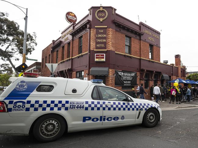 MELBOURNE, AUSTRALIA - OCTOBER 24: Police close down a pub in Richmond and ask patrons to go home, after they stood in the streets attempting to socially distance from one another. No fines were issued, on October 24, 2020 in Melbourne, Australia. The Geelong Cats take on Richmond Tigers in the AFL Grand Final on Saturday 24 October at the Gabba in Brisbane. It is the first time the AFL Grand Final has been played outside of the MCG due to COVID-19 restrictions. (Photo by Daniel Pockett/Getty Images)