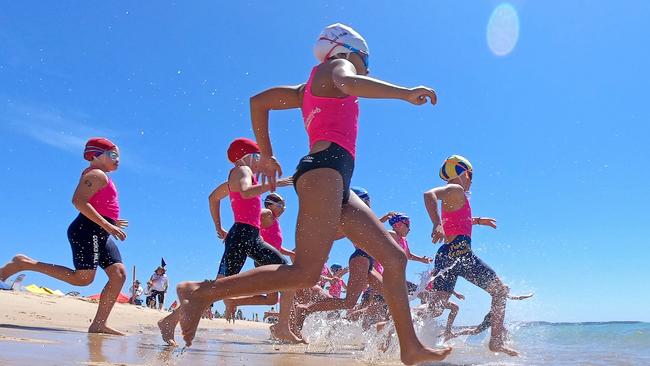 Competitors hit the water during the final of the under-10 Female Surf Race at the NSW Surf Life Saving Championships at Blacksmiths Beach on Friday, 28 February, 2020. Picture: Troy Snook