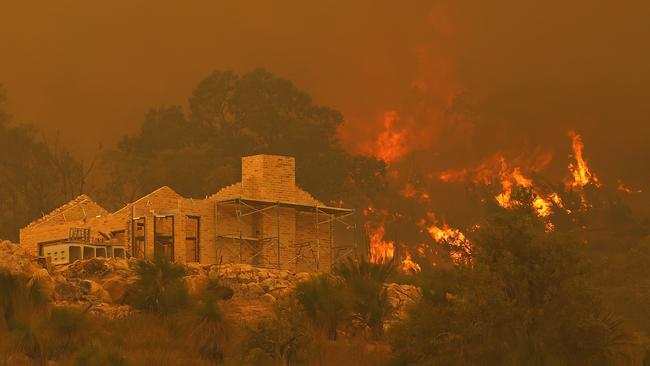 Flames surround a property under construction off Copley Road in Upper Swan, Western Australia, on Tuesday. Picture: Getty Images