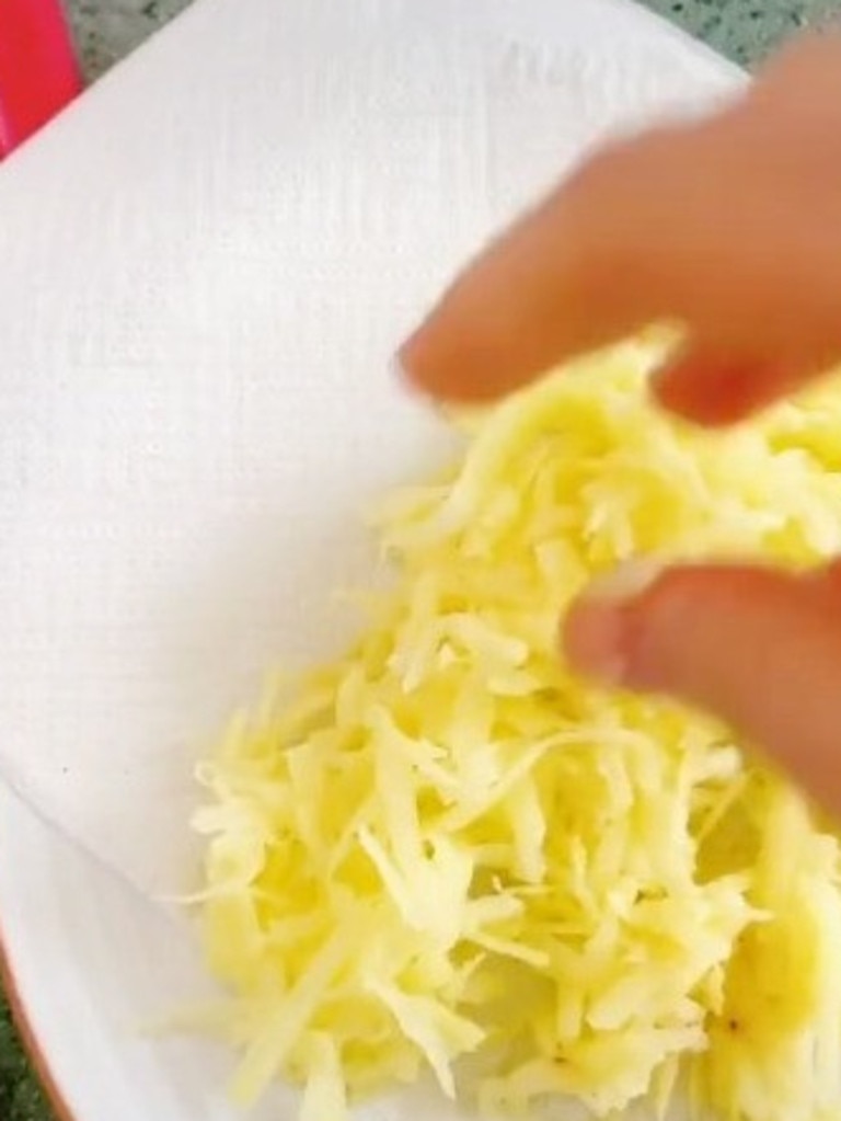 First, grate a potato and dab it dry with a paper towel. Picture: TokTok / Poppy Cooks