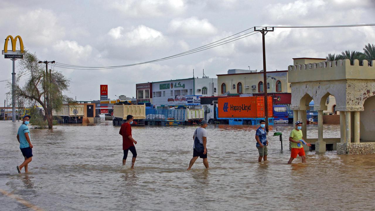 People wade through a flooded street in the northern town of al-Mussanah on October 4. Picture: Mohammed Mahjoub/AFP