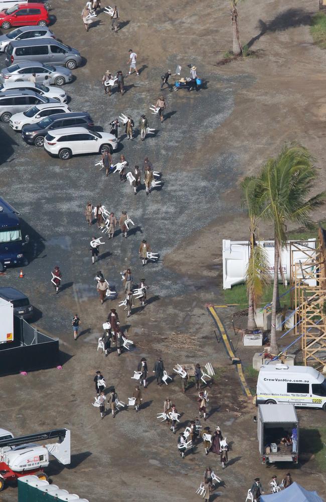 Extras dressed in period costume transport plastic chairs to the centre of the set. Picture by Scott Fletcher