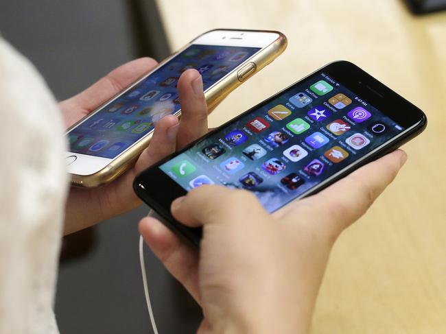 FILE - In this Sept. 16, 2016 file photo, Lisa Gao compares a new jet black iPhone 7, right, with her iPhone 6 at the Apple Store in Chicago. Qualcomm says Appleâ€™s refusal to pay royalties related to technology used in smartphones will take a big bite out of its profit and revenue. Apple Inc. has sued Qualcomm, saying the chipmaker is abusing its control over essential technology and charging excessive licensing fees. Qualcomm says Apple has indicated that it wonâ€™t pay fees until the dispute is resolved. Representatives for the Cupertino, California-based iPhone did not immediately respond to a request for comment Friday, April 28, 2017.   (AP Photo/Kiichiro Sato)