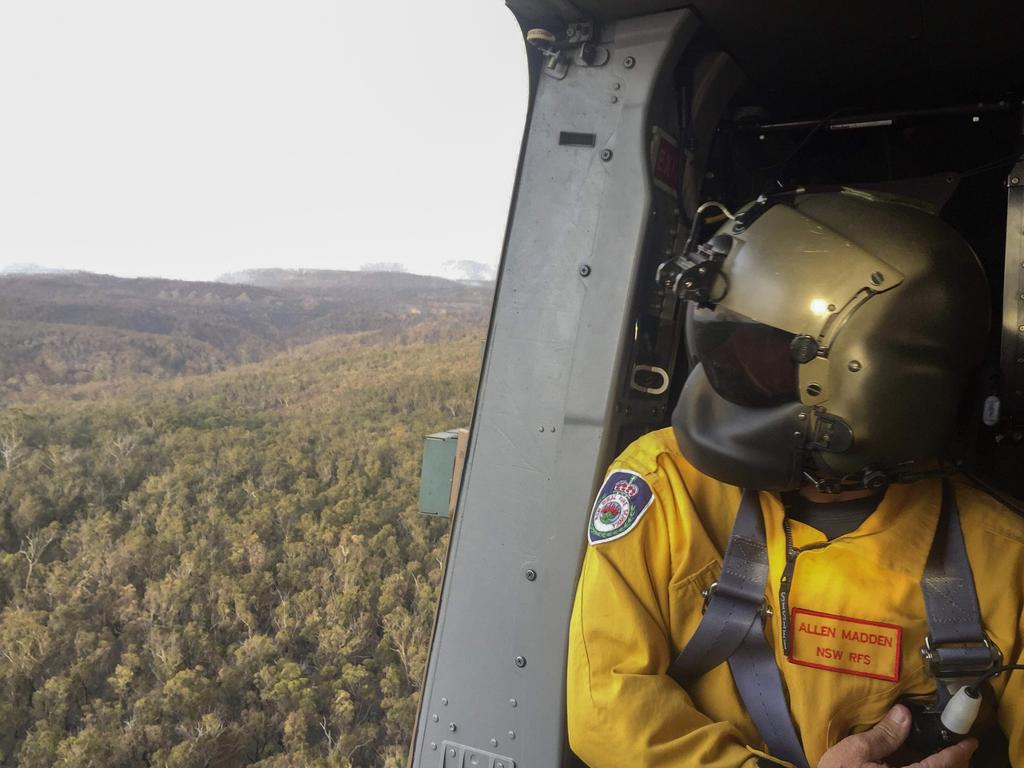 Rural Fire Service employee Mr Allen Madden assesses the Grose Valley bushfire in the Blue Mountains National Park during a sortie on an 808 Squadron MRH90 Taipan Military Support Helicopter. Picture: ADF