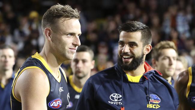 Wayne Milera, with his arm in a sling, right, congratulates Brodie Smith after his 150th game. Picture SARAH REED