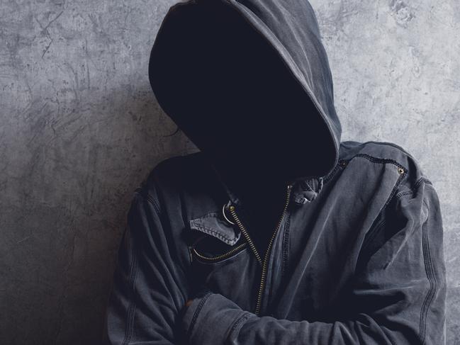 Faceless unknown and unrecognizable man with hood in dark room, spooky criminal person.