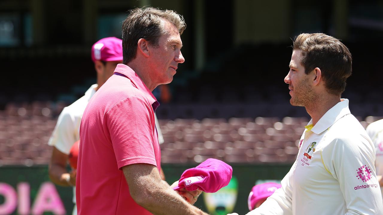 Glenn McGrath presents a baggy pink cap to the Australian captain Tim Paine. 