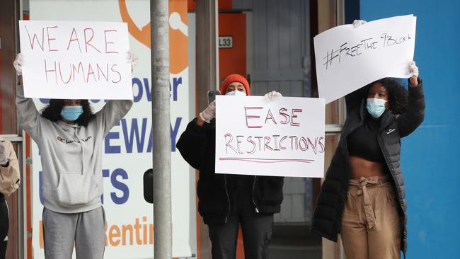 A small group of protesters are seen on site but were turned away by police as police continue to monitor a lockdown at the Government housing towers in Racecourse Rd at Flemington on Monday. Picture: David Crosling