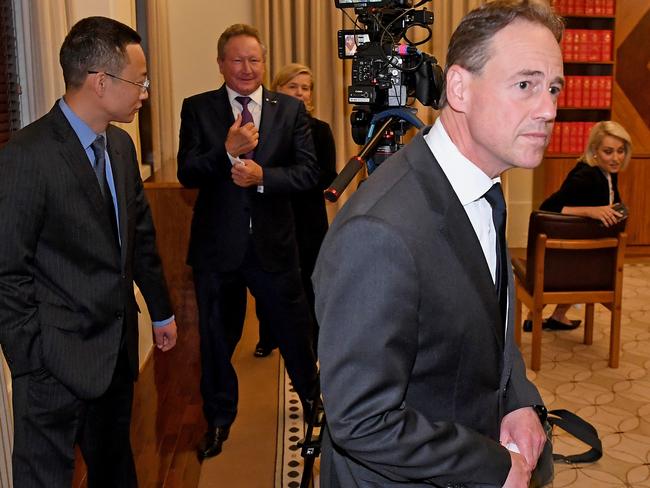 A grim-faced Greg Hunt leaves Wednesday’s press conference, with China consul-general Long Zhou and Andrew Forrest trailing behind. Picture: James Ross/AAP