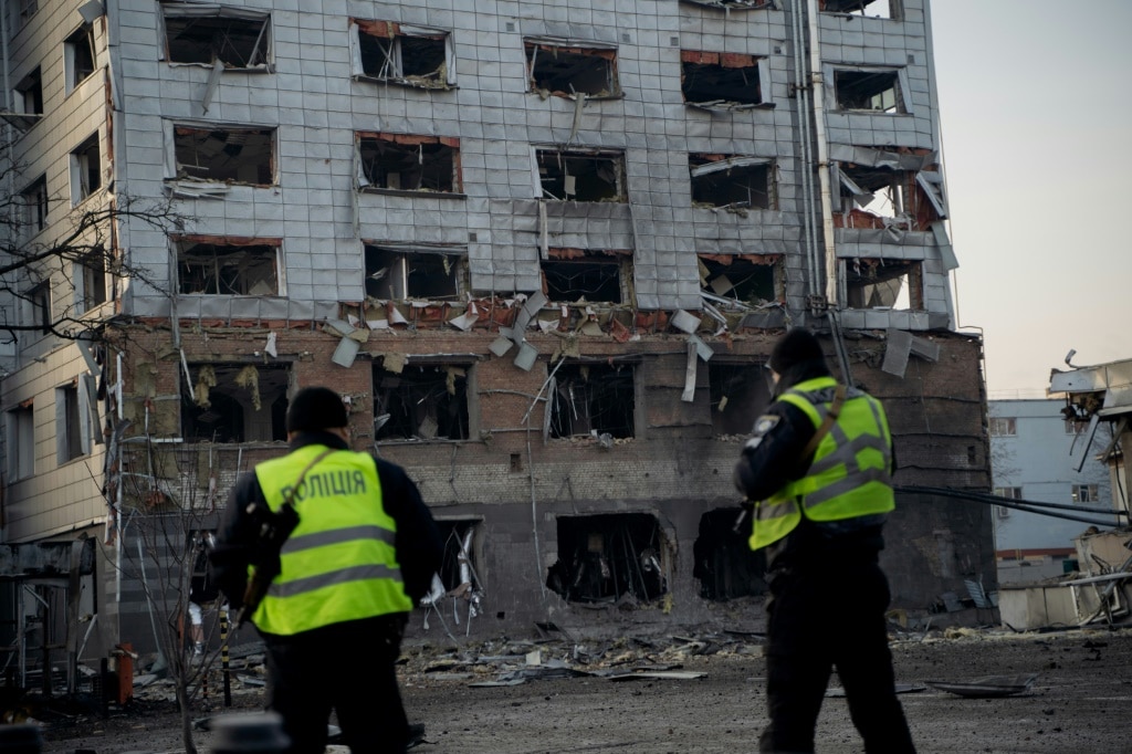 Police officers look at a damaged building after a missile attack in Kyiv on February 12, 2025