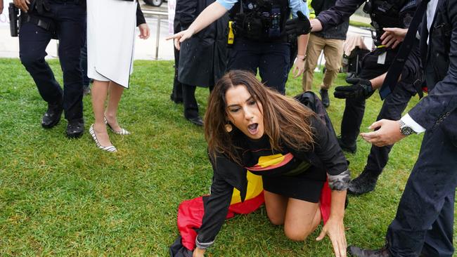 Grassed up: Senator Lidia Thorpe crawls away after being caught be the fuzz for attempting to lunge at activist Kellie-Jay Keen, aka Posie Parker. Picture: AAP