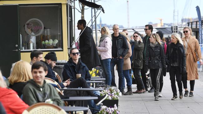 People line up to buy ice cream at a popular ice cream parlourin Stockholm. Picture: AFP.