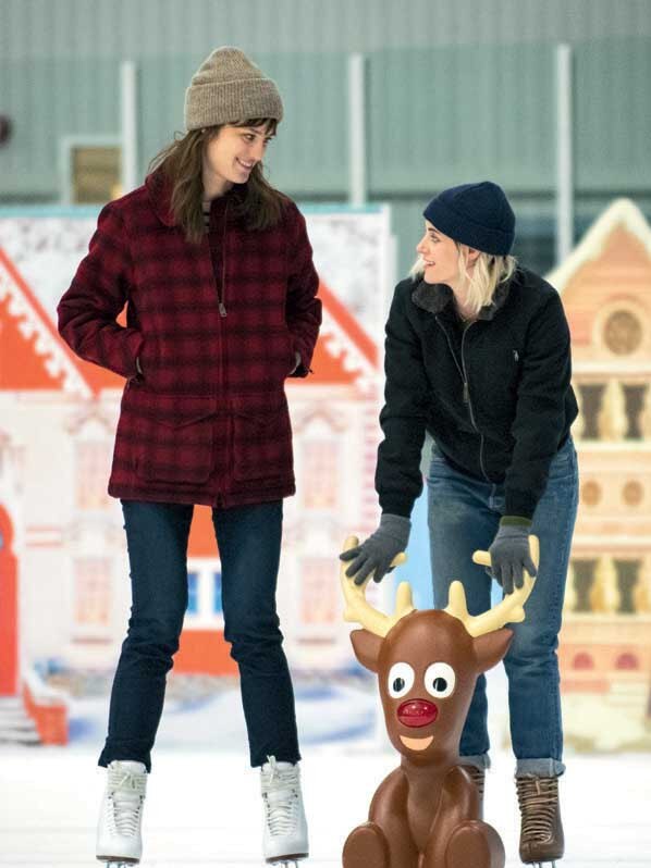 Mackenzie Davis as Harper and Kristen Stewart as Abby on the ice in Happiest Season.