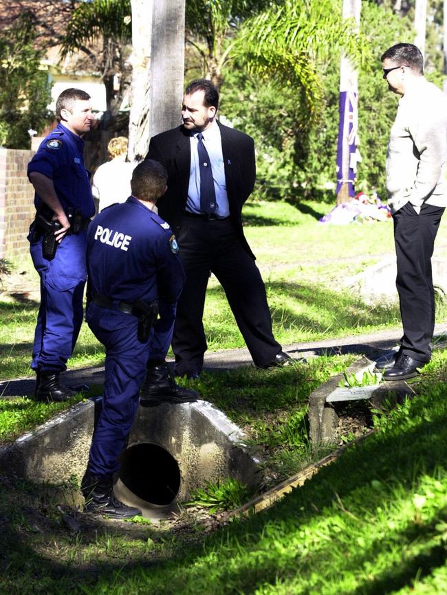 Police officers examine the scene, June 18 2003