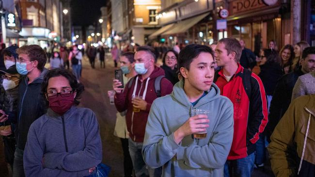 People finish their drinks in the street as bars are being emptied in Soho, in central London on the first day of the new earlier closing times for pubs and bars in England and Wales, introduced to combat the spread of the coronavirus. Picture: Tolga Akmen/AFP