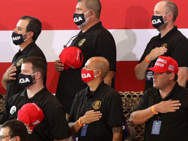 YUMA, AZ - AUGUST 18: Supporters of U.S. President Donald Trump stand for the national anthem before a campaign rally at The Defense Contractor Complex on August 18, 2020 in Yuma, Arizona. Trump excoriated presumptive Democratic nominee former Vice President Joe Biden as being soft on illegal immigration as Democrats hold their convention this week remotely from Milwaukee. Hundreds waited in line in 104-degree heat to see the president, many without masks or maintaining distance from others, according to published reports. The crowd size inside the hangar was limited in a nod to the ongoing pandemic that has hit Yuma County particularly hard.   Sandy Huffaker/Getty Images/AFP == FOR NEWSPAPERS, INTERNET, TELCOS & TELEVISION USE ONLY ==