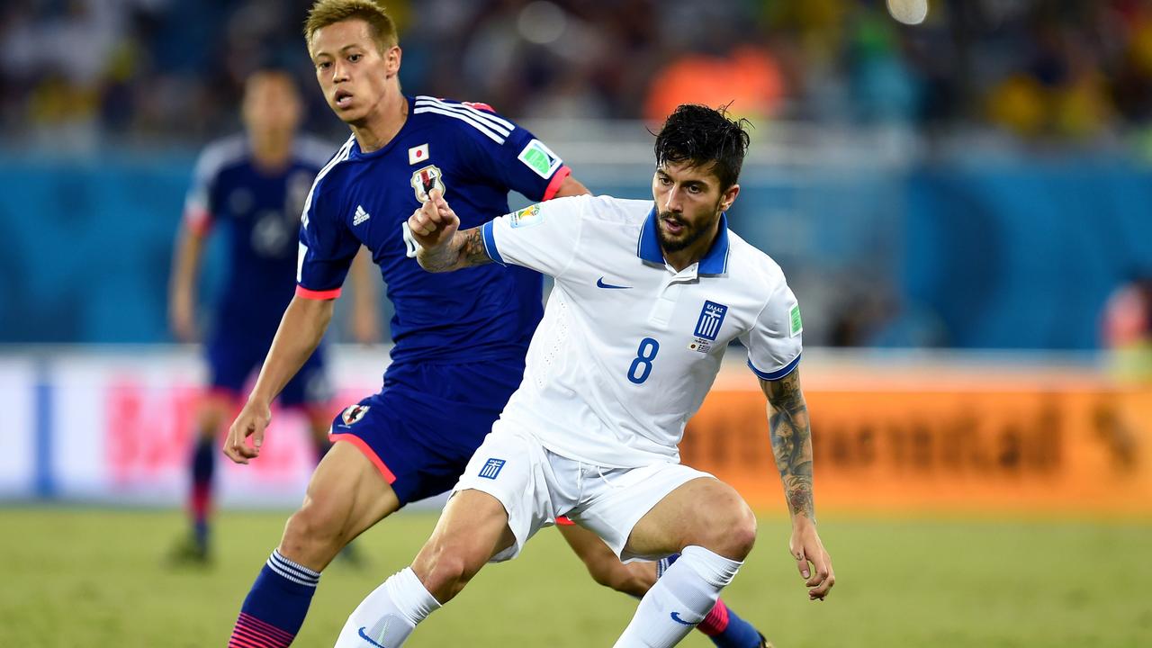 Panagiotis Kone competes for the ball with Keisuke Honda at the 2014 World Cup.